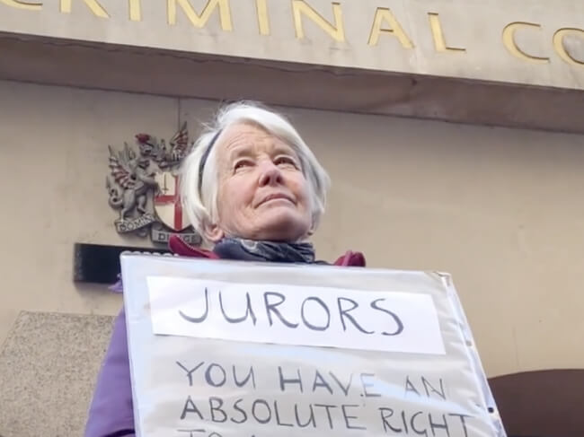 Trudi Warner stands outside a crown court holding a sign which reads 'Jurors ~ You have an absolute right...'